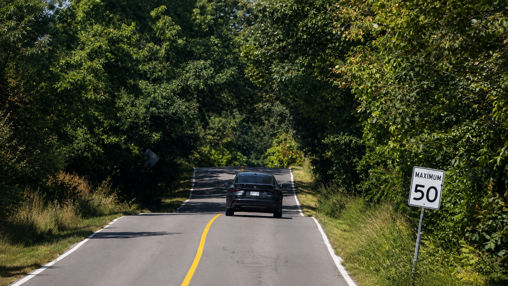A car travelling along the wooded section of King Road in Burlington near the area known for its magnetic hill.